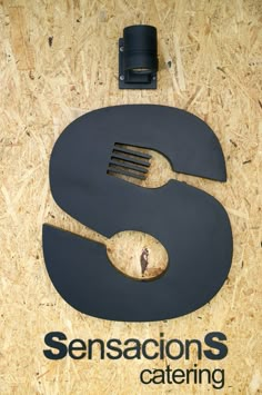 the letter s is made out of metal and has a spoon and fork in it