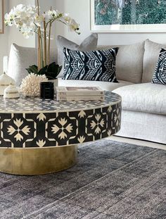 a living room filled with furniture and flowers on top of a table in front of a couch