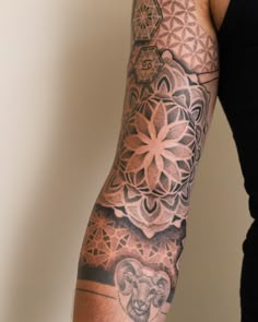 a man's arm with an intricate tattoo design on the arm and shoulder,