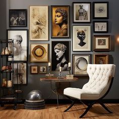 a chair and table in front of a wall with pictures on it