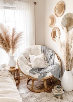 a room with white walls and lots of pillows on the floor next to a round chair