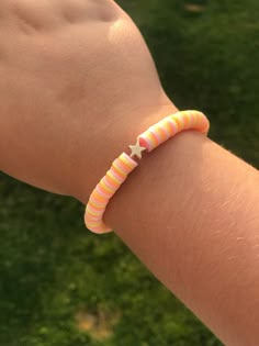 a person's arm with a pink and orange striped bracelet on top of it