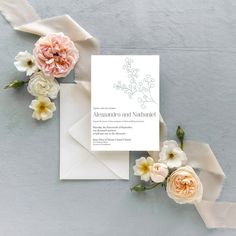 the wedding stationery is laid out with flowers