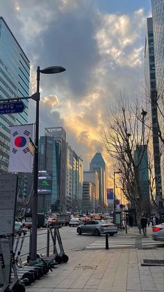 cars are parked on the street in front of tall buildings with skyscrapers behind them