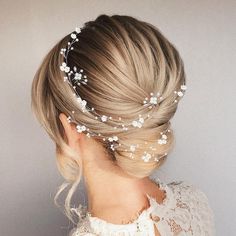 a woman with blonde hair wearing a white flowered headpiece