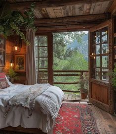 a bed in a room with lots of windows and rugs on the floor next to it