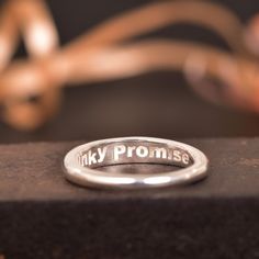 a ring with the words mikey prome written on it sitting on a piece of wood