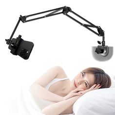 a woman laying in bed under a desk lamp