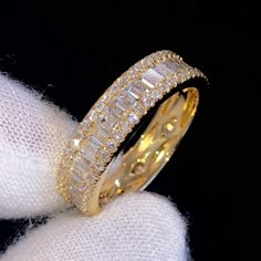 a yellow gold wedding band with baguettes and diamonds on the inside of it