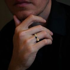 a man wearing a gold ring and black shirt