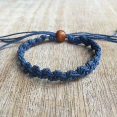 a blue bracelet with a wooden bead on it sitting on top of a table