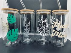 four glass tumblers with different designs on them