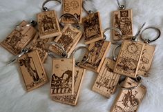 a bunch of wooden key chains with pictures on them