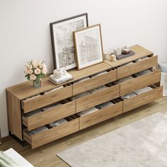 a wooden dresser with drawers and pictures on top