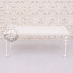 a white bench sitting in front of a wall