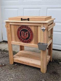 a wooden cooler sitting in front of a garage door