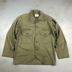 VINTAGE ' Military Army Faded Green Fatigue OG Button Down Shirt sz Lrg Adult CONDITION : Wear and fading from age. Stains/ marks around front, sleeves and back. Missing name patches. Great fading throughout. Overall good condition! This shirt has been washed* - Please review pictures* TAGGED SIZE : ** Mens Adult L** ( Fits : Mens L ) MEASUREMENTS : *Please see photos above for measurements. *Disclaimer: All measurements are in inches and are taken laying flat on the ground* *Please review pictu Vintage Pre-washed Fall Shirt, Military Style Long Sleeve Tops With Relaxed Fit, Military Style Cotton Tops With Snap Buttons, Vintage Green Button-up Shirt, Military Style Button-up Tops With Snap Buttons, Khaki Cotton Tops With Snap Buttons, Military Button-up Shirt, Military Style Button-up Tops, Relaxed Fit Military Cotton Top