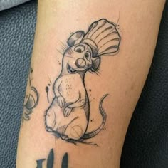 a cartoon mouse tattoo on the leg of a person's leg, with an ink drawing