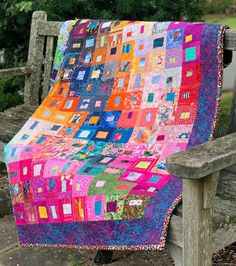 a colorful patchwork quilt on a wooden bench