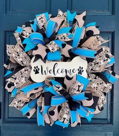 a blue and black wreath with a bone for someone's welcome sign on it