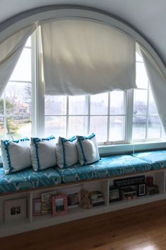 a window seat with several pillows on it