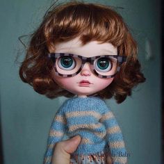 a close up of a doll wearing glasses