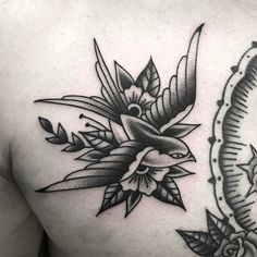 a black and white photo of a bird with flowers on it's back shoulder