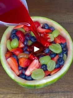 a bowl filled with fruit and juice being poured into the bowl to make it look like something out of a watermelon