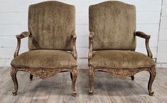 two brown chairs sitting next to each other on top of a wooden floor