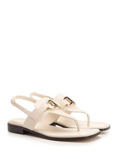 'Lula' thong sandal by Ferragamo, in white leather with double Gancini detail and flat sole. Composition: upper: 100% calf lining: 100% lamb sole: 100% bos taurus. Elegant Slingback Sandals With Leather Footbed For Beach, Elegant Beach Slingback Sandals With Leather Footbed, Elegant Toe Post Sandals With Leather Footbed, Elegant T-strap Sandals With Leather Footbed, Classic White Sandals With Single Toe Strap, White Classic Sandals With Single Toe Strap, Chic White Flat T-strap Sandals, Chic White Calf Leather Sandals, White Sandals With Leather Lining For Summer