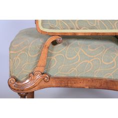 an ornately carved arm chair with blue upholstered fabric