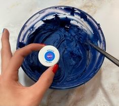 a person is painting the inside of a blue bowl