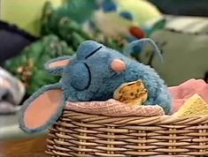 a blue stuffed animal sitting in a basket