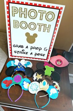 there is a photo booth with mickey mouse ears and other items on the table in front of it