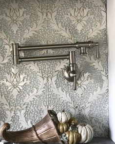 a shelf with some pumpkins on it and a wall paper behind it in a room