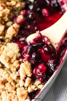 blueberry crumbler cobbler in a red dish with a wooden spatula