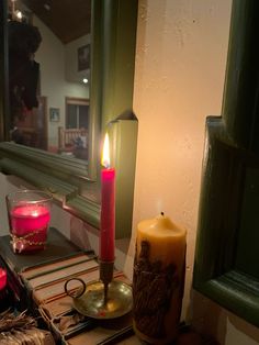 a lit candle sitting on top of a table next to a mirror and other items