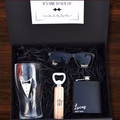 an open gift box containing two flasks, sunglasses and a hip flask