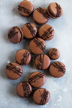 chocolate macaroons are arranged on a white surface