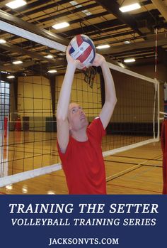 a volleyball player is reaching up to hit the ball with his racket in an indoor gym