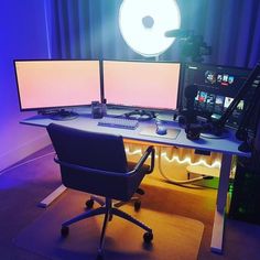 two computer monitors sitting on top of a desk