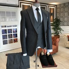 a suit and tie sitting on top of a mannequin's dummy in a living room