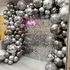 a room filled with lots of shiny silver balls and disco ball wall art on the walls