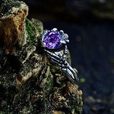 Crafted in sterling silver, this witchy engagement ring features a captivating purple stone in a nature-inspired design. Perfect as a forest promise ring, it embraces the essence of the witchy and gothic aesthetic, making it a unique and enchanting symbol of love.  Characteristics: Metal - Recycled solid sterling silver  Stone - Cubic Zirconia 7x7 mm. Finish - Oxidized. View all silver witchy rings: https://www.etsy.com/shop/TinyShinyJewel?ref=seller-platform-mcnav&section_id=44336283 Care instr Magical Sterling Silver Crystal Ring For Gift, Magical Promise Ring Jewelry, Magical Sterling Silver Jewelry For Promise, Mystical Sterling Silver Promise Ring, Gothic Sterling Silver Promise Jewelry, Gothic Sterling Silver Crystal Ring As Gift, Gothic Sterling Silver Crystal Ring For Gift, Mystical Sterling Silver Jewelry For Promise, Magical Sterling Silver Rings For Anniversary