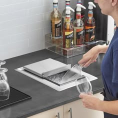 a woman pours wine into a glass in front of an ice chest with bottles on the counter