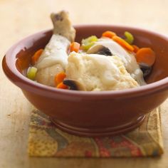 a brown bowl filled with food on top of a table