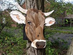 a wooden cow head mounted to a tree