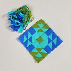 a blue and green piece of cloth next to a flower