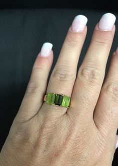 Beautiful Peridot 14K Yellow Gold Ring It is a size 6. Total weight of 3.3 grams solid 14K gold, stamped inside the ring. Features two rectangular peridot 12mm x 5mm and one rectangular dark green 12mm x 5mm center stone. I am unsure if it is an emerald? Or darker peridot. It is a beautiful ring and it will look beautiful on any one who wears it! Shipped insured/delivery confirmation I guarantee item to be exactly as described and pictured. Ruby Heart Pendant, Black Opal Pendant, Green Ring, Green Rings, Peridot Green, Initial Ring, Heart Pendant Diamond, Black Gift Boxes, Cute Rings