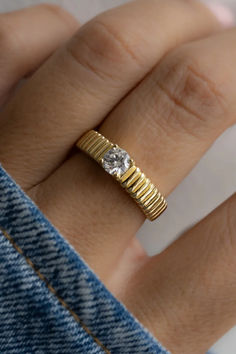 A solitaire CZ stone meets an intricate fluted band for a fresh take on a timeless design. Perfect for any occasion.